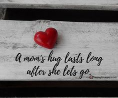 a red heart sitting on top of a wooden bench with the words, a mom's hug lasts long after she lets go