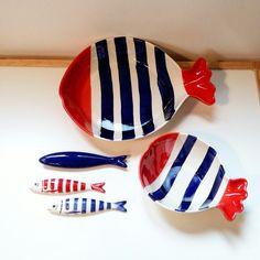 three colorful fish shaped dishes on a white counter top, one is red and the other is blue