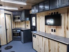 a kitchen with wooden walls and black appliances