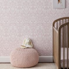 a baby's room with pink wallpaper and a crib in the corner