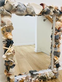 a mirror made out of seashells on a wooden floor