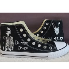 black and white converse shoes with the words donne darko on them