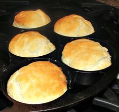 six bread rolls in a cast iron skillet cooking on the stove top, ready to be cooked