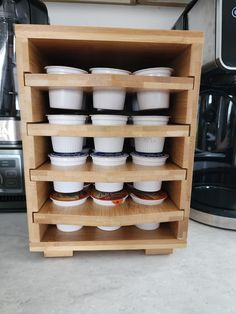 a wooden shelf filled with cups and sauces on top of a counter next to an air fryer