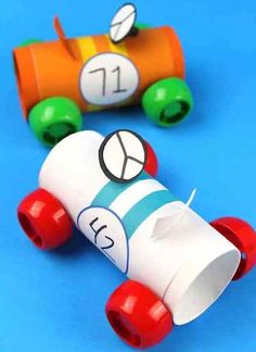 two toy cars made out of toilet paper on a blue background with the number 11