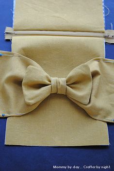 two pieces of cloth with a bow tie on them, sitting next to each other