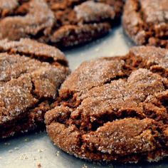 chocolate cookies with powdered sugar on top sitting on a baking sheet, ready to be eaten