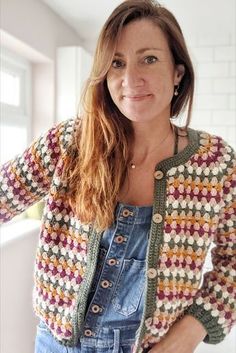 a woman wearing overalls and a crocheted cardigan