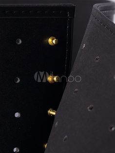 a black case with gold rivets on the front and back of it's cover