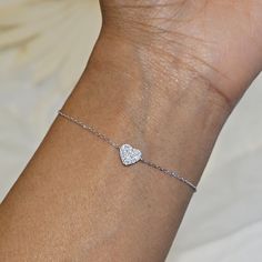 Our Dainty Silver Heart Bracelet features a delicate heart charm encrusted with CZ crystals.  This minimalist bracelet makes a great statement piece and will look great worn alone or stacked with our other bracelets. We make our jewellery in small batches to reduce wastage. Our jewellery is designed with the modern Woman in mind, elegant, unique pieces with a classic touch. Our jewellery is great for gifting, whether it's Valentines, Mothers Day, Birthday or simply a gift for a friend, sister et Silver Diamond Heart Bracelet As Gift, Heart-shaped Diamond Bracelet As Gift, Silver Diamond Heart Bracelet For Valentine's Day, Heart-shaped Diamond Bracelet Gift, Wedding Heart Bracelet With Cubic Zirconia For Valentine's Day, Diamond Bracelet With Heart Charm For Gift, Delicate Silver Heart Bracelet Gift, Diamond Bracelet With Heart Charm As Gift, Dainty Heart Bracelet For Anniversary