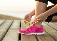 a woman tying her shoelaces on the boardwalk