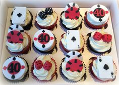 a dozen cupcakes in a box decorated with ladybugs and playing cards