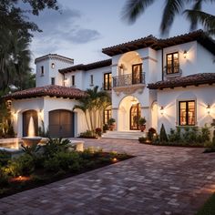 a large white house with lots of windows and lights on it's front porch