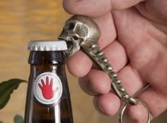 a bottle opener with a skeleton keychain attached to it