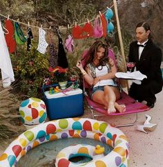 a man and woman sitting on lawn chairs next to an inflatable pool