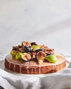 a cake topped with figs and nuts on top of a white plate