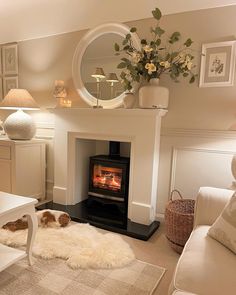 a living room filled with furniture and a fire place next to a white table topped with flowers