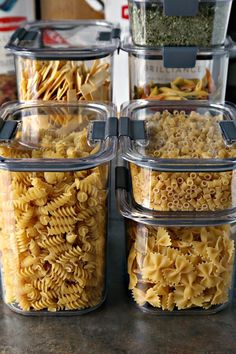 three clear containers filled with pasta sitting on top of a counter next to each other