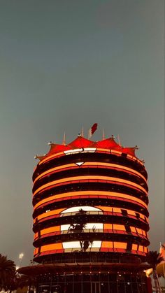 an orange and black building with red umbrellas on top