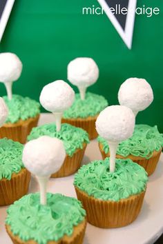 cupcakes with green frosting and marshmallows on top are arranged on a plate