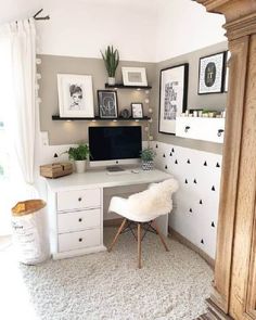 a white desk with a computer on top of it in a room filled with pictures