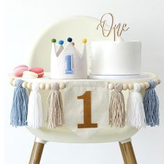 a table with a cake and decorations on it, including a one - year birthday banner