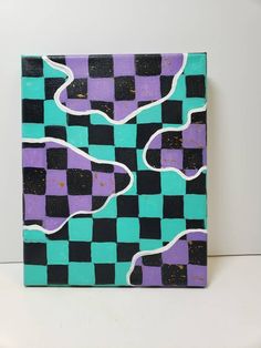 a purple and blue checkered painting on a white wall