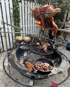 an outdoor grill with various foods cooking on it