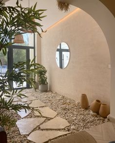 the interior of a house with stone flooring and circular mirrors on the wall above it