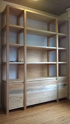 an empty room with wooden shelves and drawers