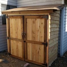 a wooden storage shed sitting next to a house