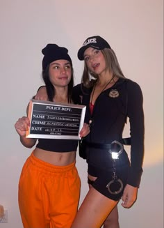 two women dressed up in costumes posing for the camera with a sign that says police dept