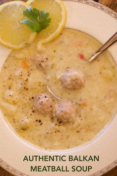 a bowl of soup with meatballs and lemon on the side