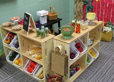 an assortment of fruits and vegetables on display in front of a wall with green walls