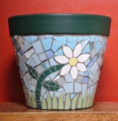 a flower pot sitting on top of a wooden shelf