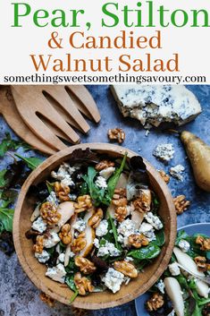 a wooden bowl filled with spinach, walnuts and feta cheese on top