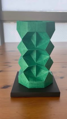 a green sculpture sitting on top of a wooden table