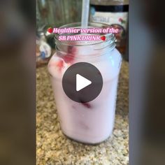 a jar filled with pink liquid sitting on top of a counter