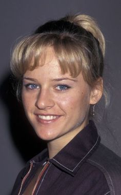 a woman with blonde hair and blue eyes smiling