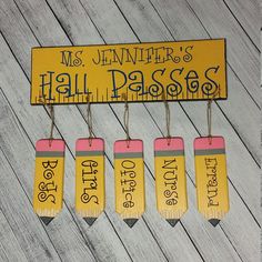 four yellow and pink name tags hanging from clothes pins on a wooden background with the words, mrs jenny's hall passosch