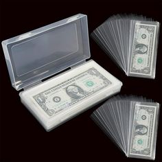 four stacks of one hundred dollar bills in a clear plastic case on a black background