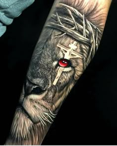 a lion with a cross on his head and red eyes is shown in this tattoo