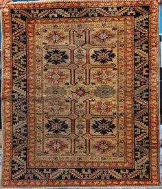 an old rug hanging on the side of a building with blue skies in the background