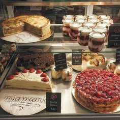 a display case filled with cakes and pies