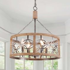 a wooden chandelier hanging from a ceiling in a room with white walls and windows