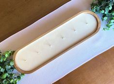 a piece of cheese sitting on top of a table next to green plants and leaves