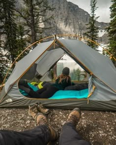 a person laying in a tent with their feet on the ground