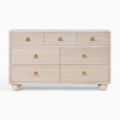 the chest of drawers is made from wood and has gold knobs on each drawer