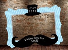 a photo frame with a mustache and top hat on it, in front of a brick wall