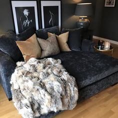 a living room filled with furniture and pillows on top of a hard wood floored floor